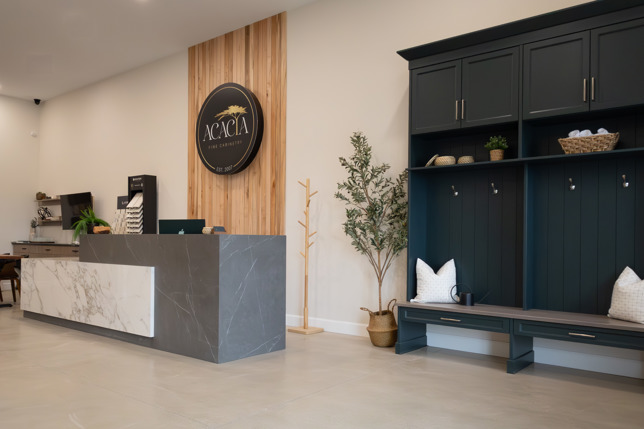 Interior stone counter, dark green cabinetry, Acacia sign
