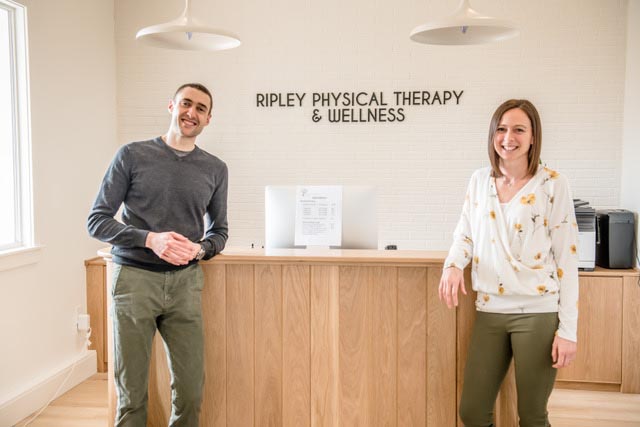 man and woman standing at a desk